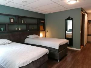 a room with two beds and a mirror in it at Hotel Lemmenhof in Ell