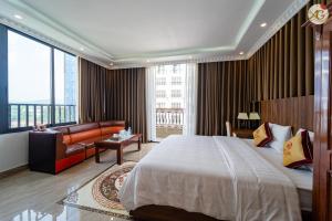 um quarto de hotel com uma cama grande e um sofá em Tamundi Cao Bằng- An Gia Hotel- City Center em Hoàng Ngà