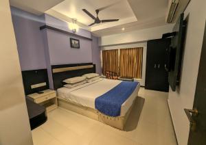 a bedroom with a bed and a ceiling fan at RBS Residency in Tiruchchirāppalli