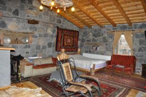 a bedroom with a bed and a couch and a chair at Doğunun Taş Evleri in Selim