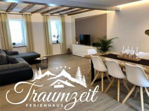uma sala de estar com uma mesa e cadeiras brancas em Spacious apartment near ski-lift em NeuhÃ¼tten