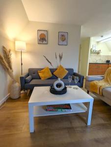 ein Wohnzimmer mit einem Sofa und einem weißen Couchtisch in der Unterkunft Cosy Chic Ipswich Flat in Bramford