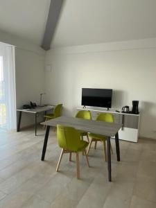 een eetkamer met een tafel en groene stoelen bij Appartement 17 in Oerlinghausen
