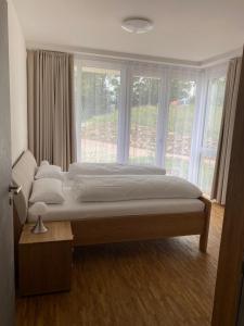 a large bed in a room with a large window at Suite 32 in Oerlinghausen