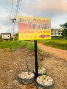ein Schild in der Mitte einiger Reifen mit Pflanzen in der Unterkunft Baan phuwamin in Ko Lanta
