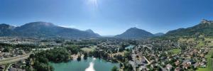 an aerial view of a town with a river and mountains at Appartement tout confort proche lac in Thyez