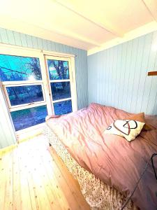 ein Schlafzimmer mit einem Bett und zwei Fenstern in der Unterkunft Svalemosej 42 in Strøby Egede