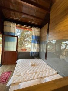 ein großes Bett in einem Zimmer mit Fenster in der Unterkunft Cát Tiên Hotel in Cat Tien