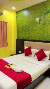 a bedroom with a bed with red pillows on it at Hotel Avenue Regency in Mumbai