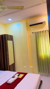 a hotel room with a bed and a window at Hotel Avenue Regency in Mumbai