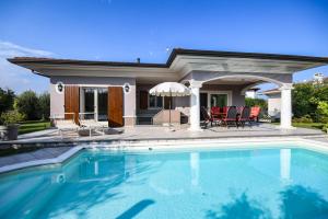 a swimming pool in front of a house at Villa Erika in Manerba del Garda