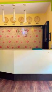 a white counter with pink flowers on a wall at Hotel Avenue Regency in Mumbai