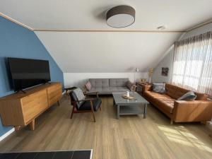 sala de estar con sofá y TV de pantalla plana en "Apartment New Series 3a", en Dändorf