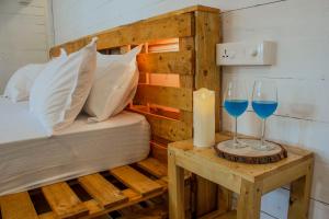 a bed and two glasses of blue wine on a table at The Pearl Beach Resort in Canacona