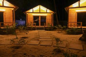 una casa sulla spiaggia di notte di The Pearl Beach Resort a Canacona