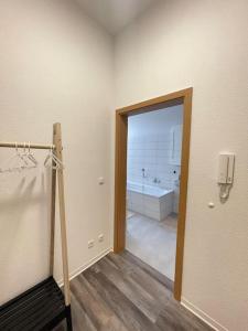 ein Badezimmer mit einer Badewanne und einer Tür, die zu einem Badezimmer mit einer Badewanne führt. in der Unterkunft Moderne und stilvolle Wohnung direkt am Teich in Altenburg