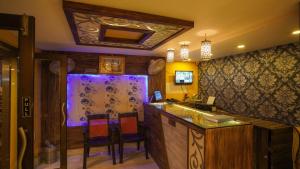 - une cuisine avec un bar, des chaises et un évier dans l'établissement Hotel Shantinivas, à Tarapith