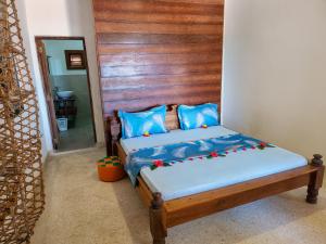 a bedroom with a bed with a wooden headboard at Villa NOAH BEACH ZANZIBAR in Kiwengwa
