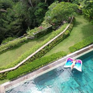 una persona en una balsa en una piscina en Ayawana Private Villas Managed by ARM Hospitality, en Tegalalang