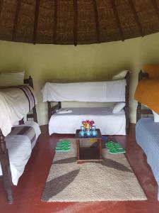 a room with two beds and a table in it at The Great Circle Lodge in Nanyuki