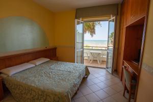 a bedroom with a bed and a view of the ocean at Hotel Roma Sul Mare in Roseto degli Abruzzi