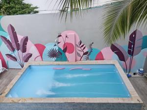 a swimming pool in front of a wall with a mural at Bm-14G Charming Cartagena Lodge with Shared Pool and Private Terrace in Cartagena de Indias