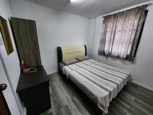 niewielka sypialnia z łóżkiem i oknem w obiekcie Hillside Villa w mieście Kampong Kundassan