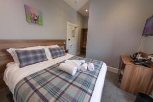 1 dormitorio con 1 cama con toallas en Northern Sands Hotel, en Dunnet