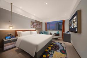 ein Hotelzimmer mit einem Bett und einem TV in der Unterkunft Insail Hotels Guangzhou Beijing Road Pedestrian Branch in Guangzhou
