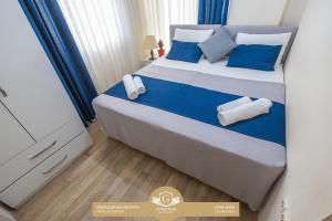 a bedroom with a bed with blue and white pillows at Gunduzler Deluxe Hotel - Antalya Center in Antalya