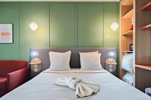 a bedroom with a bed with towels on it at Aparthotel AMMI Nice Lafayette in Nice