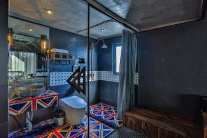 a bathroom with a shower with a blue wall at Wuzhen Qiuxi Art Hotel in Tongxiang