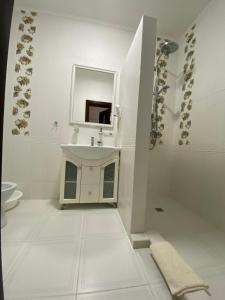 a white bathroom with a sink and a mirror at Oasis Karpat in Polyana