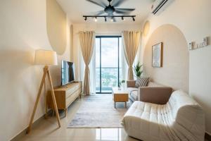 een woonkamer met een bank en een tv bij Muji Home Lavile KL Sunway Velocity 双威永乐城中文房东Pool in Kuala Lumpur