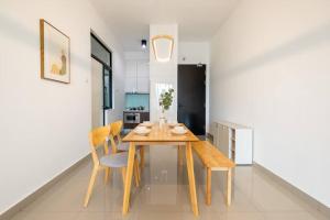 a dining room with a wooden table and chairs at Muji Home Lavile KL Sunway Velocity 双威永乐城中文房东Pool in Kuala Lumpur