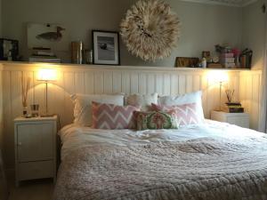 a bedroom with a large bed with pillows and two lamps at Charmigt hus på Vindö in Stockholm