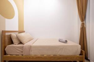 a bed in a room with a white wall at Muji Home Lavile KL Sunway Velocity 双威永乐城中文房东Pool in Kuala Lumpur