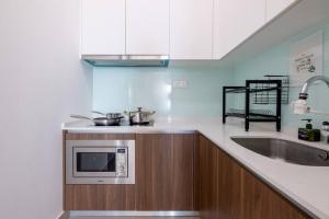 a kitchen with a sink and a microwave at Muji Home Lavile KL Sunway Velocity 双威永乐城中文房东Pool in Kuala Lumpur