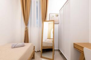 a mirror in a room with a bed and a chair at Muji Home Lavile KL Sunway Velocity 双威永乐城中文房东Pool in Kuala Lumpur