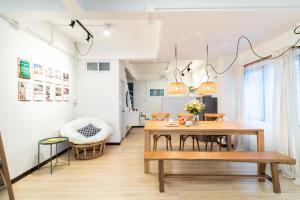 une salle à manger avec une table et un banc dans l'établissement Merry House Chiang Mai, à Chiang Mai