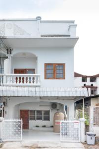 une maison blanche avec un balcon au-dessus dans l'établissement Merry House Chiang Mai, à Chiang Mai