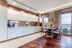 a kitchen with white cabinets and a table and chairs at Apartament francuski in Gdańsk