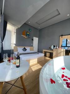 een slaapkamer met een bed en een tafel met wijnglazen bij AroRy Hotel in Da Lat