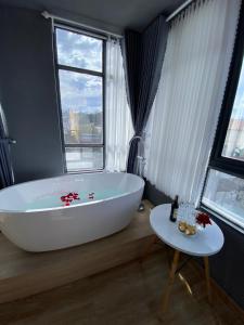 een groot wit bad in een badkamer met een raam bij AroRy Hotel in Da Lat