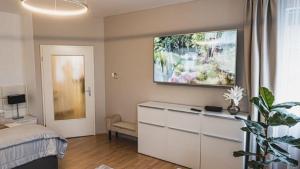 a bedroom with a bed and a painting on the wall at Rosegarden Apartman in Sárospatak