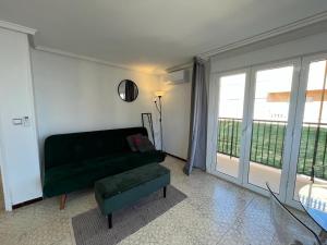 Marbella Sea View Apartament في آريناليس ديل سول: غرفة معيشة مع أريكة خضراء ونافذة