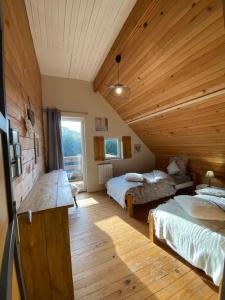 um quarto com 2 camas e um tecto de madeira em Chalet en bordure de forêt em Betton