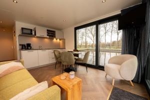 a living room with a couch and a table at Welcome in - Houseboat - Paviljoenwei 4 - Sneek 'Boatique Sneek' in Offingawier +18 photos