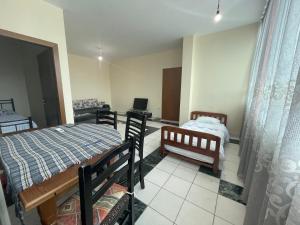 a room with two beds and a table and chairs at Bajovah Apartments & Restaurant in Tirana