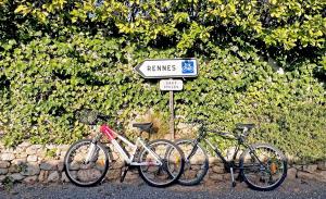 Deux vélos sont garés à côté d'un panneau indiquant la rue. dans l'établissement L'OlivierBlanc, à Vendémian